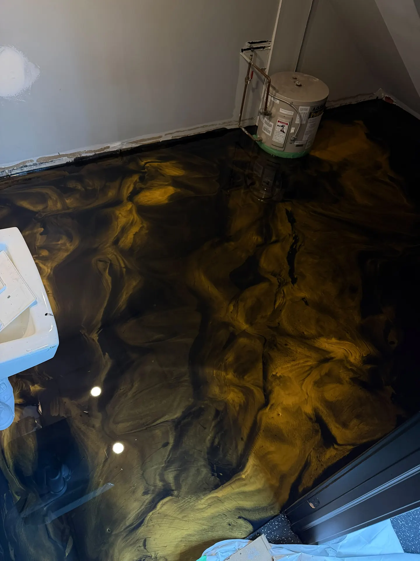 Black and gold metallic epoxy bathroom floor, by Westside Mogul Resin in Calgary