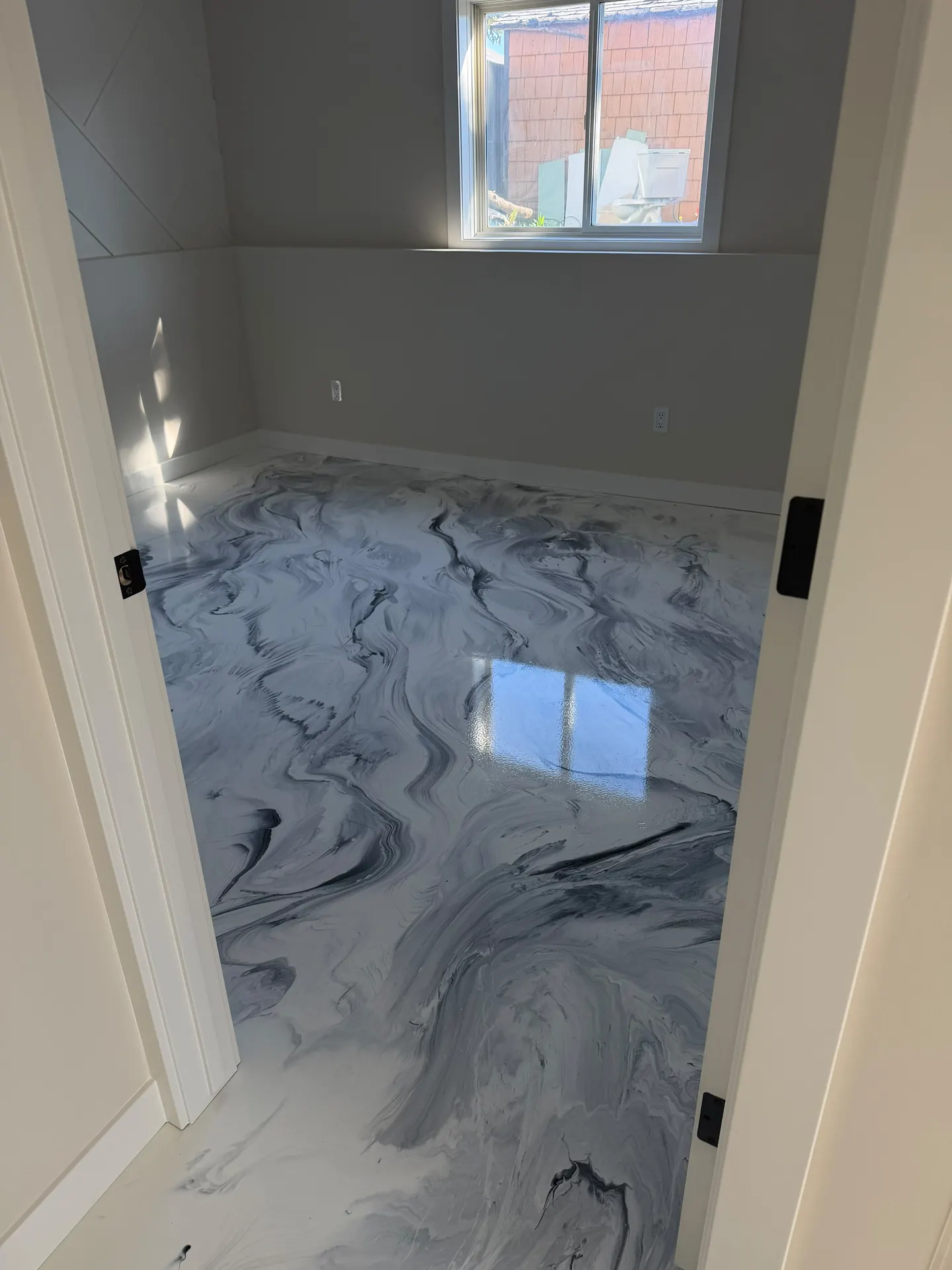 White and black marble metallic epoxy floor, doorway view, by Westside Mogul Resin in Calgary